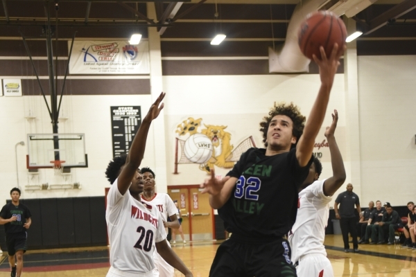 Green Valley‘s Xavier Jarvis (32) goes up for a lay-up against Las Vegas defenders Eri ...