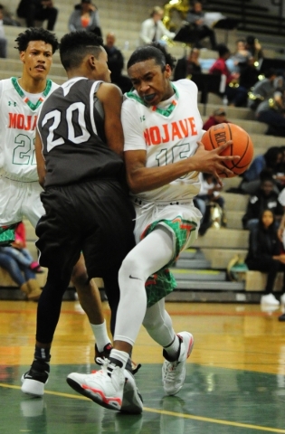 Mojave guard Richard Edwards, right, fouls Cheyenne forward William Federson (20) in the thi ...