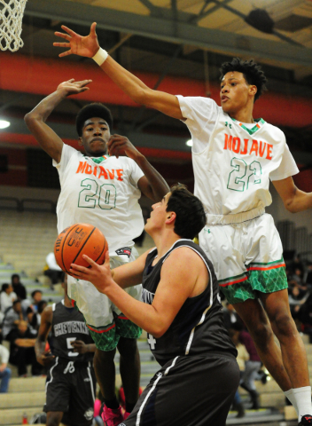 Mojave forwards Chris Jackson (20) and Chrishawn Thomas (22) defend a layup attempt by Cheye ...