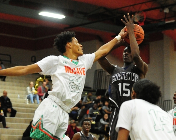 Mojave forward Chrishawn Thomas (22) blocks the shot of Cheyenne wing Dewayne Alexander (15) ...