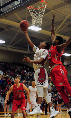 Desert Oasis forward Drevin Cannon, lfet goes up for a shot as Arbor View guard Jarrod Burks ...