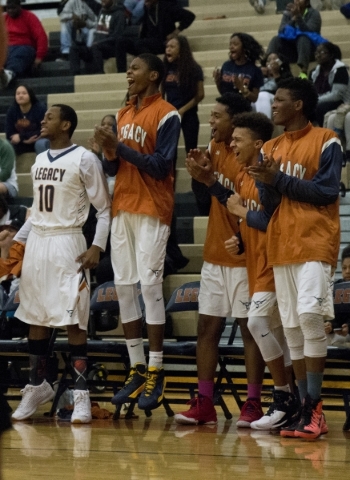 Members of the Legacy High School boys basketball team celebrate from the bench during their ...