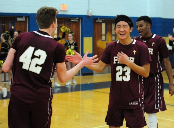 Faith Lutheran players Josh Hong (23) and Elijah Kothe (42) celebrate their 97-89 quadruple ...