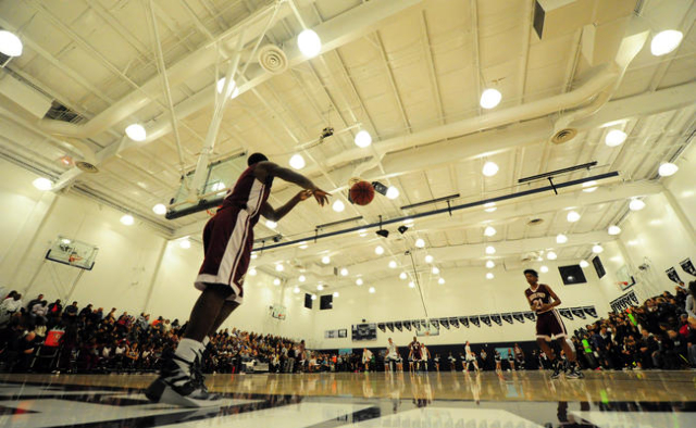 An overflow crowd can be seen as Agassi Prep guard Stephan Laushaul passes the ball inbounds ...