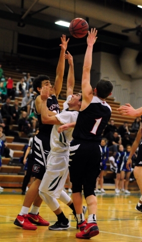 Green Valley guard Ryan Trejo, center, goes up for a shot against Coronado guards Trey Hurlb ...