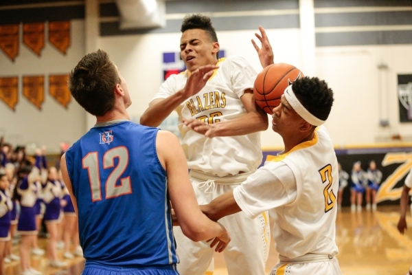 Bishop Gorman senior Zach Collins (12), blocks Durango junior Jeremie Portuondo (32) as he m ...