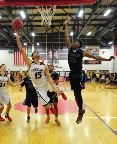 Coronado guard Bryce Savoy (15) goes up for a shot against Silverado guard Errol Newman (23) ...