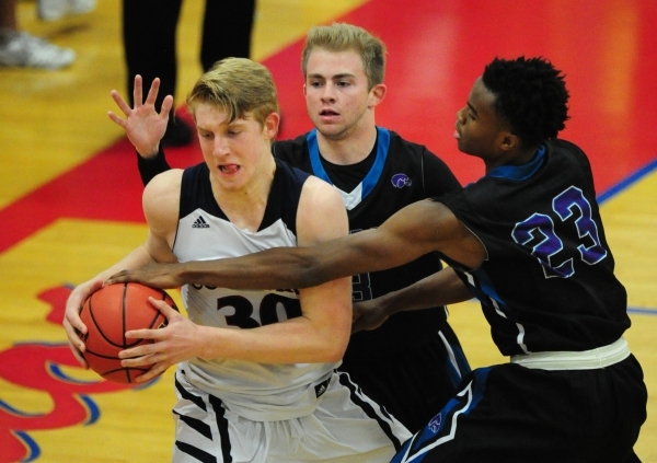 Silverado guards Evan Tafoya and Errol Newman (23) fight Coronado forward Kennedy Koehler (3 ...