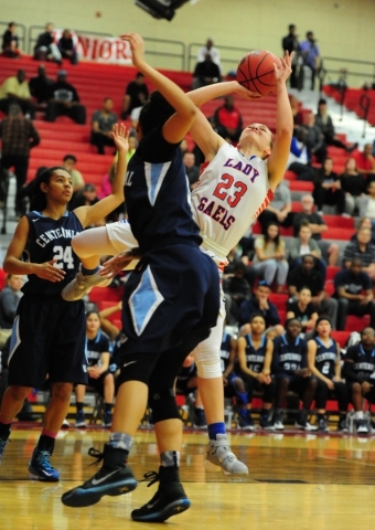 Bishop Gorman guard Megan Jacobs (23) falls while taking a shot against Centennial guard Jay ...