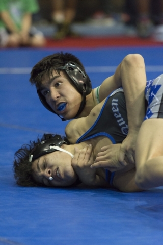 Desmond Bowers, back, of Green Valley High School wrestles David Montes of McQueen High Scho ...