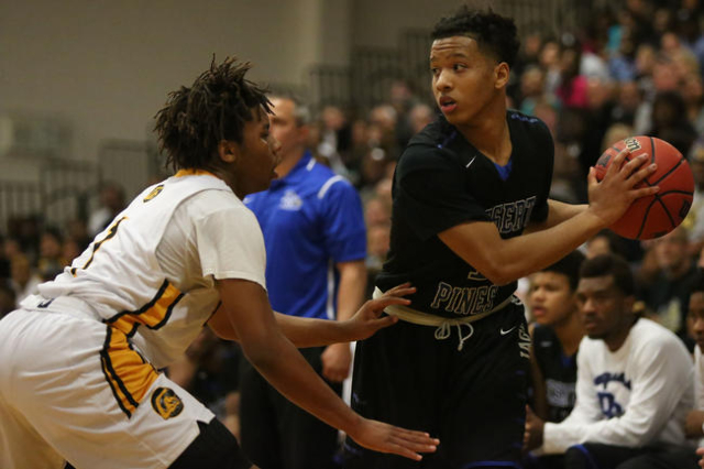 Desert Pines High School junior Capri Uzan (1) looks for an open teammate while being guarde ...