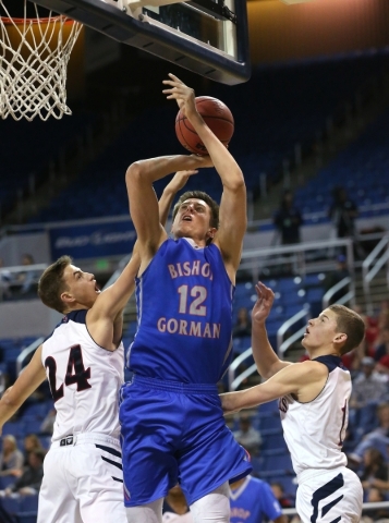 Bishop Gorman‘s Zach Collins shoots over Coronado defenders Jake Desjardins, left, and ...