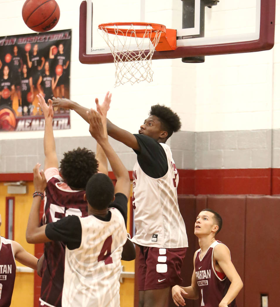 Cimarron-Memorial’s Brian Washington, right, jumps for a rebound during teams practice ...