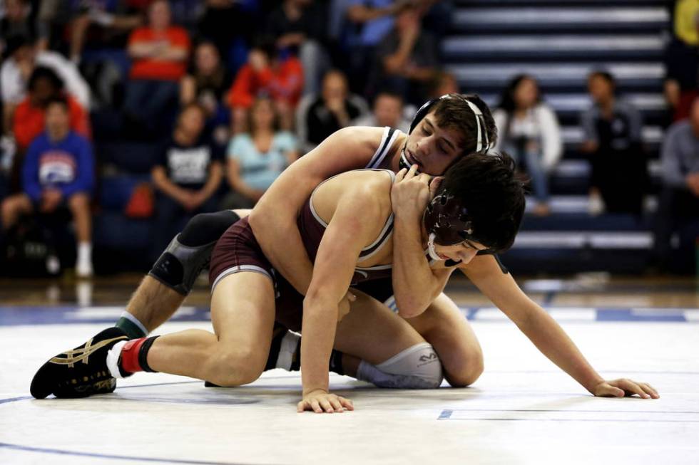 Nico Antuna, of Centennial High School, tries to pin Daniel Rodriguez, of Cimarron-Memorial ...