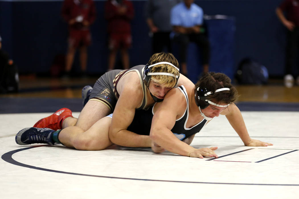 A Faith Lutheran High School player pins down a Centennial High School player during the Sun ...