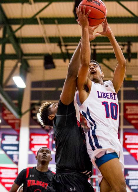 Liberty’s Jordan Holt (10) goes up for a shot while Las Vegas’ Jaylin Headen (34 ...