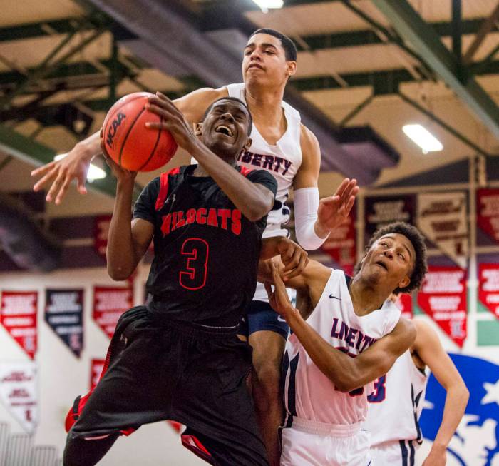 Las Vegas’ KJ Johnson (3) goes up for a shot against Liberty defenders Julian Strawthe ...