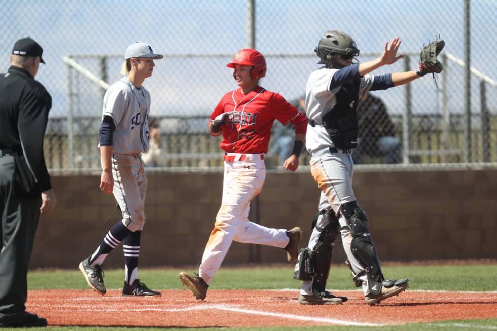 Las Vegas baserunner crosses the plate as the Rim of the World (Calif.) catcher waves off th ...