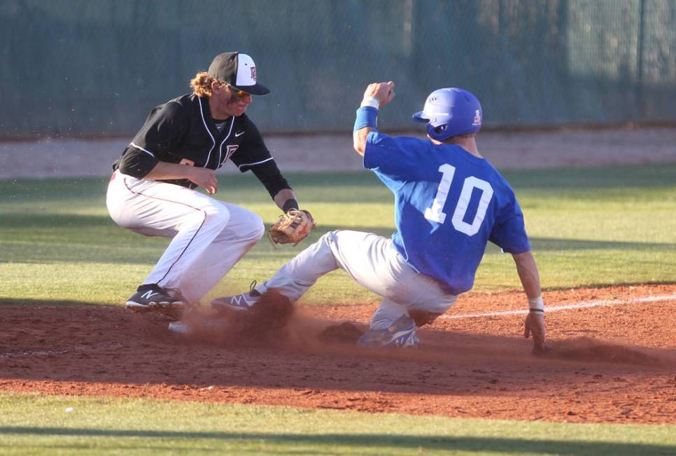 Green Valley baserunner Carter Gehlken (10) slides safely into third base under the tag of Z ...