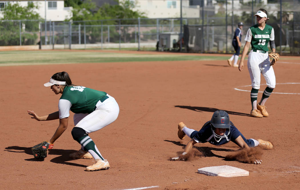 Coronado baserunner Aleah Baldonado (4) dives safely into third base as Green Valley infield ...