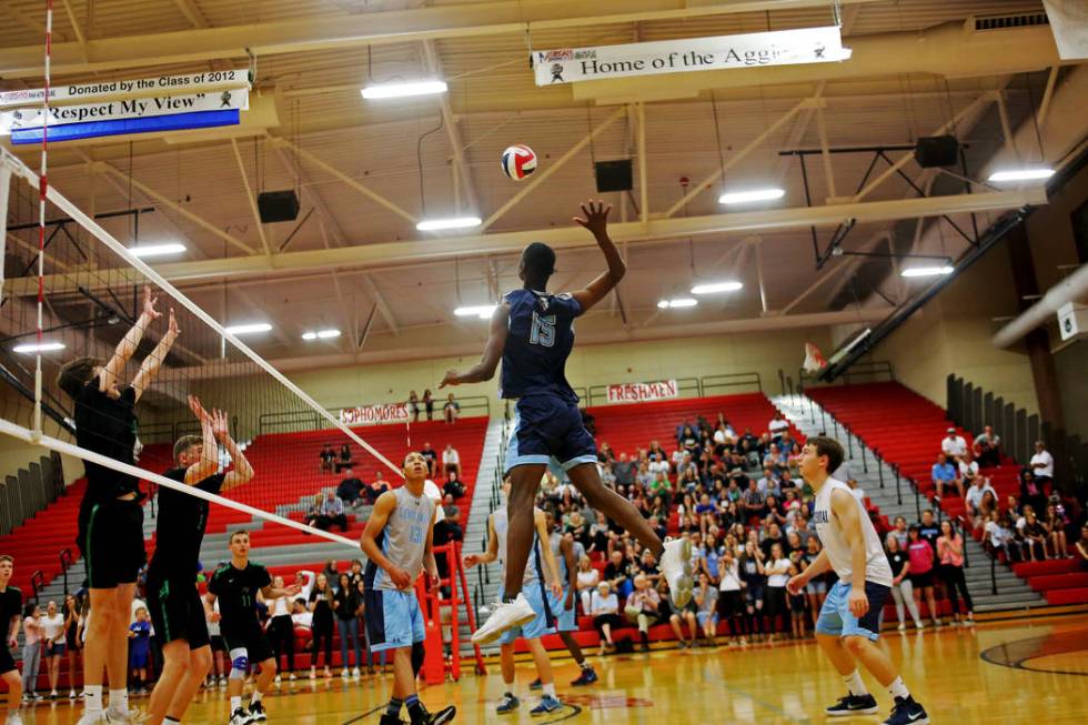 Centennial High School’s Nhamani Brown (15) spikes the ball as teammate Teon Taylor (1 ...