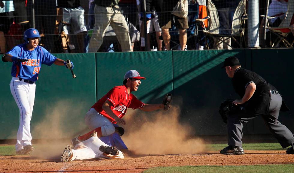 Arbor View’s Zach Quintana shows the ball to the umpire after tagging out Bishop Gorma ...