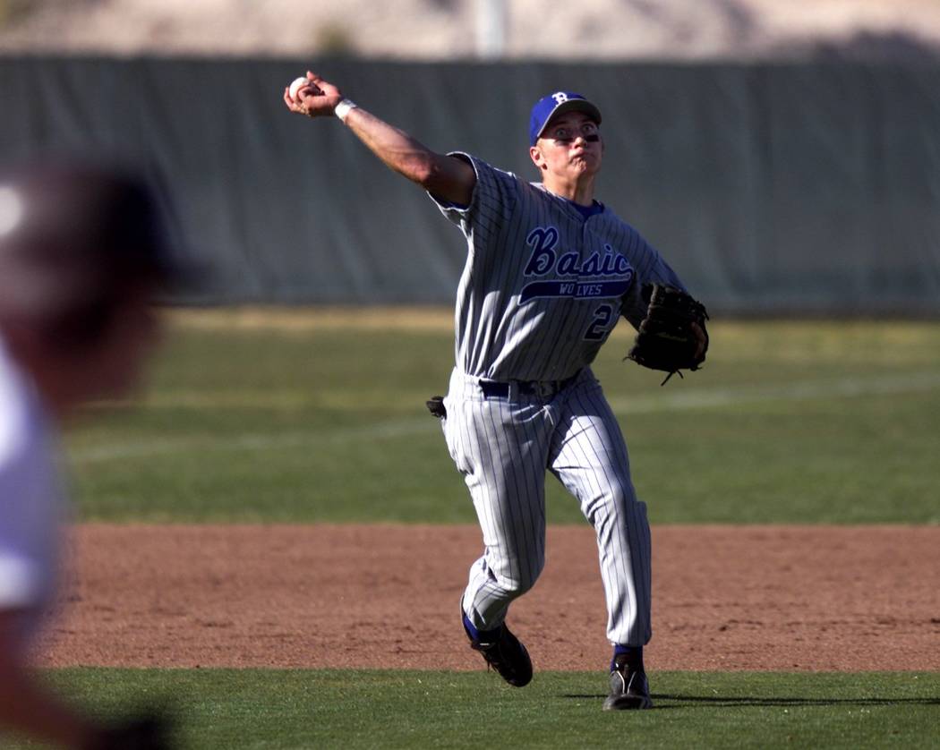 Basic High School third baseman Micah Schnurstein throws to first base during a game against ...