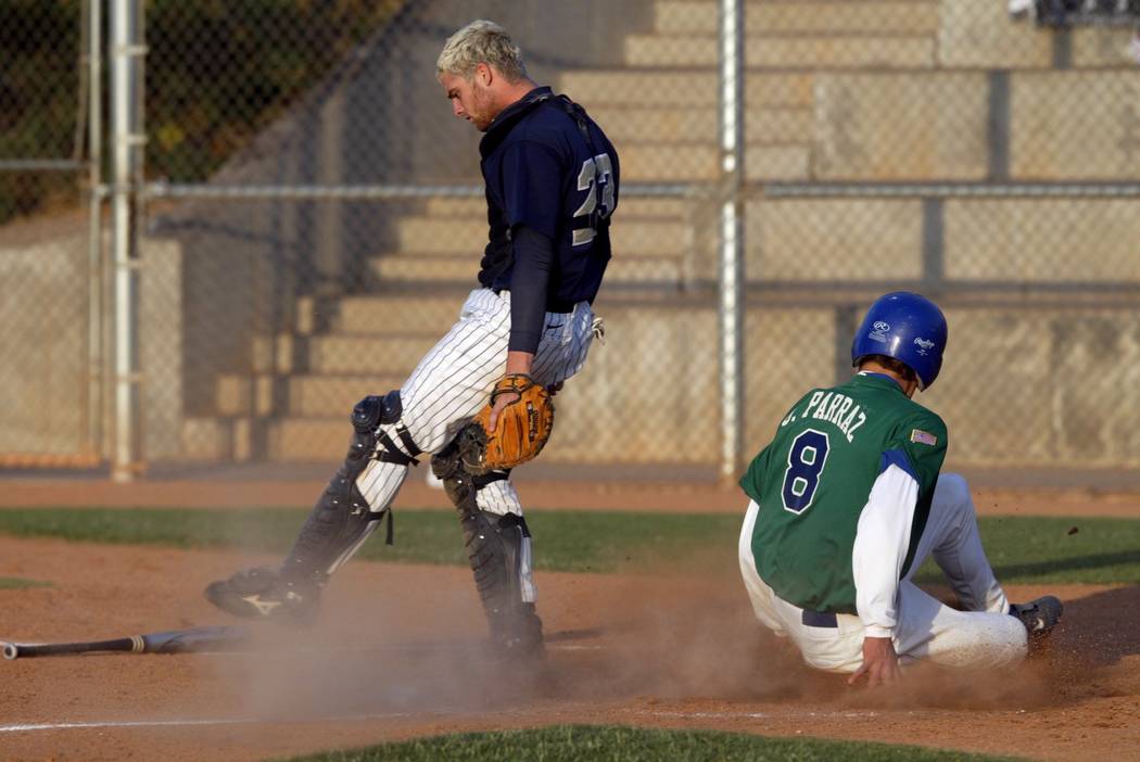 Green Valley baserunner Jordan Parraz scores from second base on a bunt as Foothill catcher ...