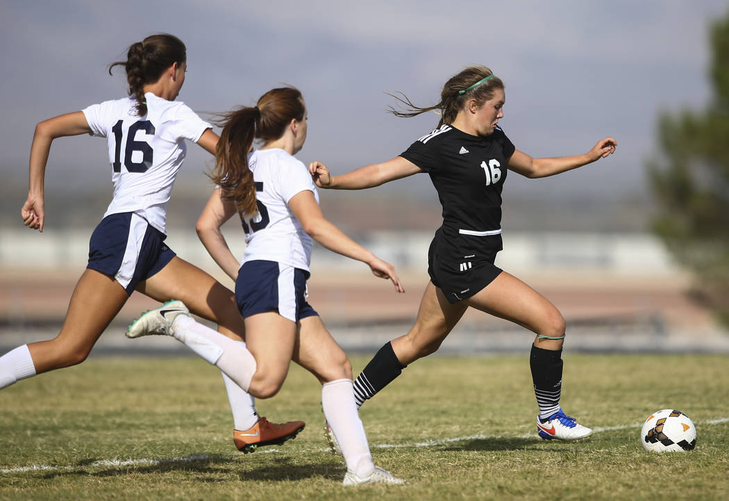 Palo Verde’s Olivia Packer, right, moves the ball past Centennial’s Savannah Tar ...