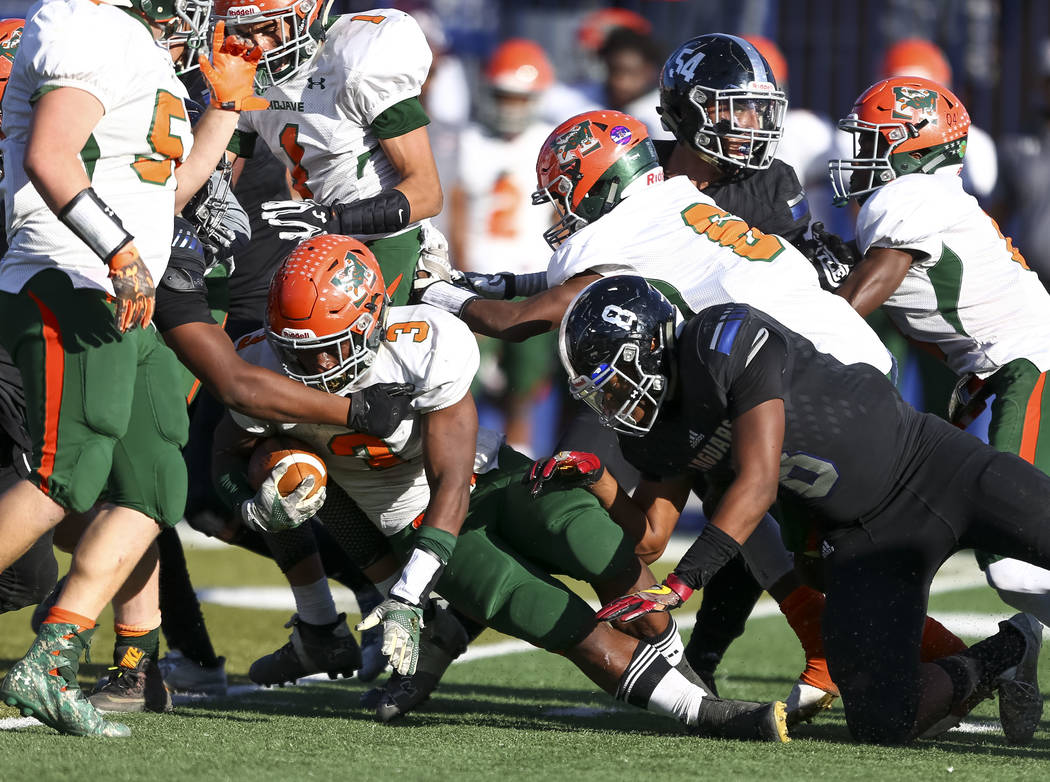 Mojave’s Tawee Walker (3) is brought down by Desert Pines defenders during the NIAA Cl ...