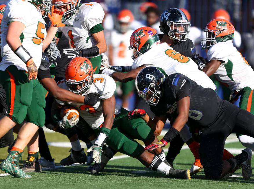 Mojave’s Tawee Walker (3) is brought down by Desert Pines defenders during the NIAA Cl ...