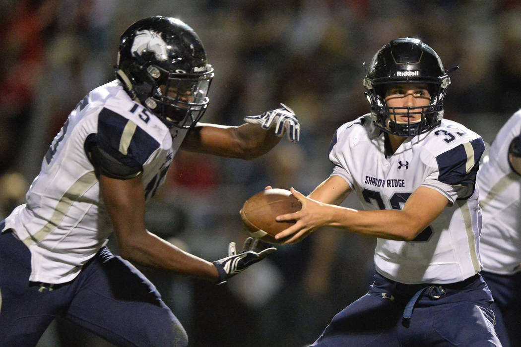 Shadow Ridge quarterback Kody Presser (33) hands the ball off to running back Malik Lindsey ...