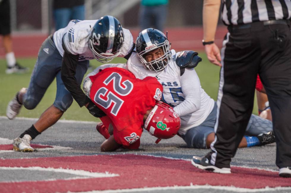 Arbor View Aggie running back Kyle Graham (25) gets tackled by Desert Pines Jaguar corner ba ...