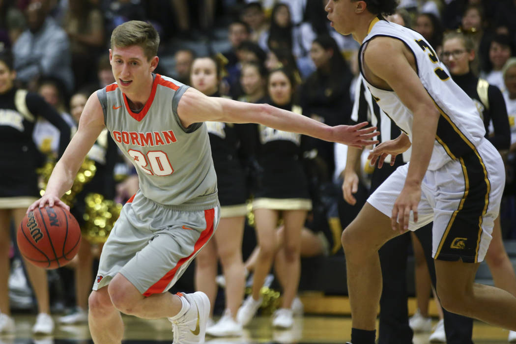 Bishop Gorman’s Noah Taitz (20) drives past Clark’s Ian Alexander (32) during a ...