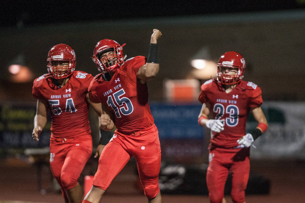 Arbor View Aggie linebacker Billy Davis (15) celebrates a touchdown with his teammates Tai T ...