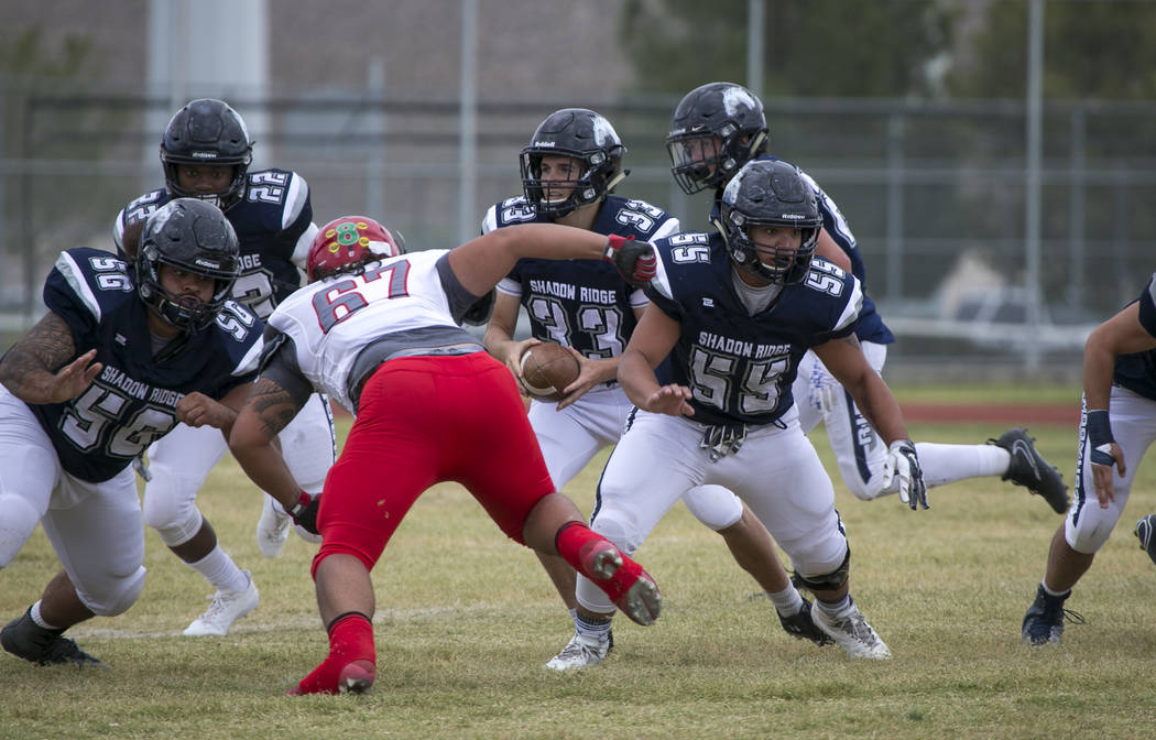 Shadow Ridge quarterback Kody Presser (33) looks for the hand off during a football game aga ...