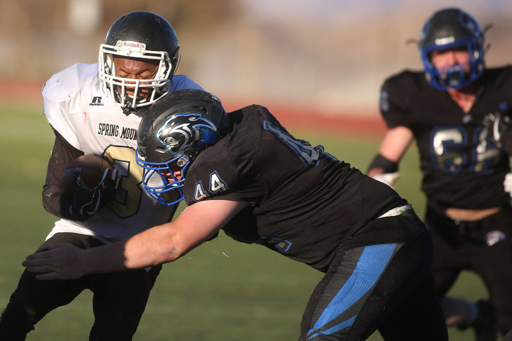 Pahranagat Valley player Garett Higbee (44) takes down Spring Mountain player Shawn Shumpert ...