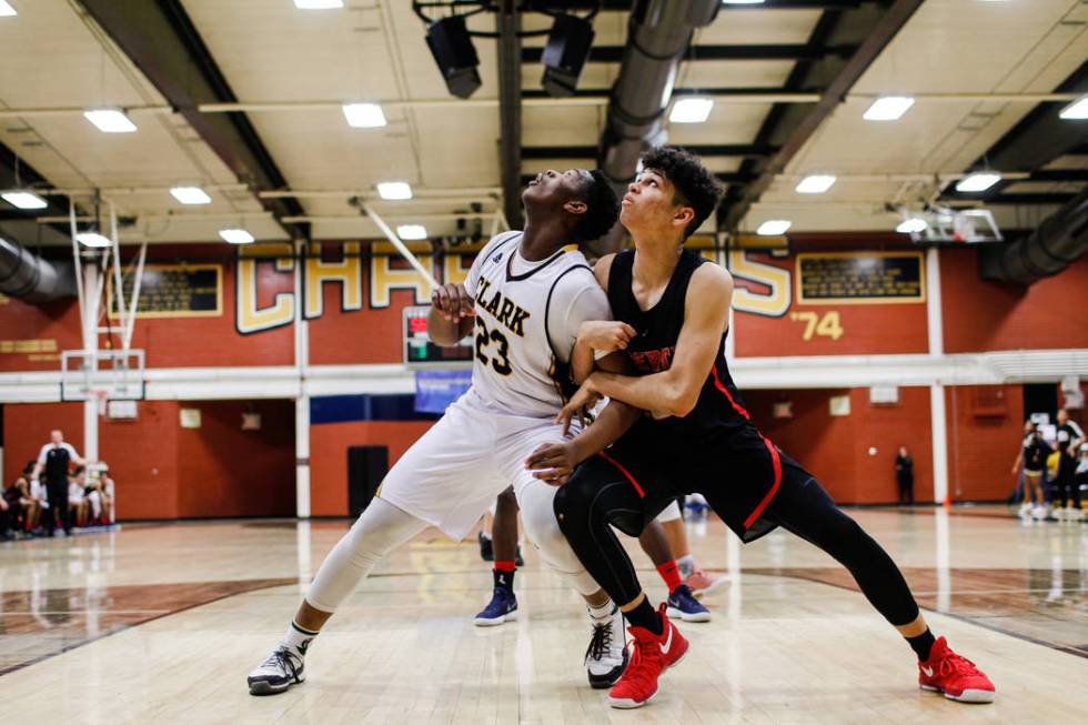 Clark Chargers’ Antwon Jackson (23) and Liberty’s Terrance Marigney (13) look up ...