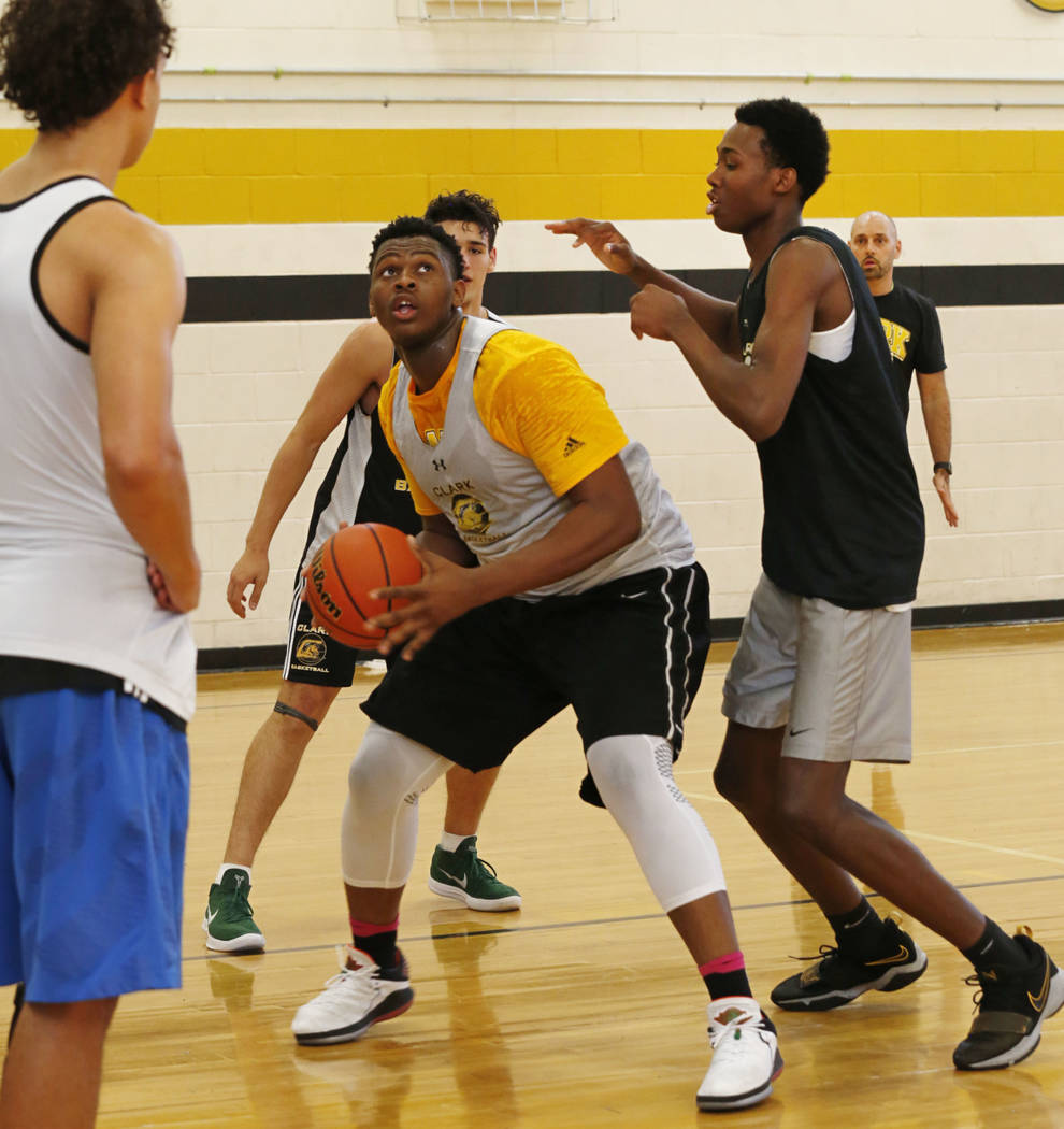 Clark forward-center Antwon Jackson, center, keeps a ball away from his teammate Iverson Smi ...
