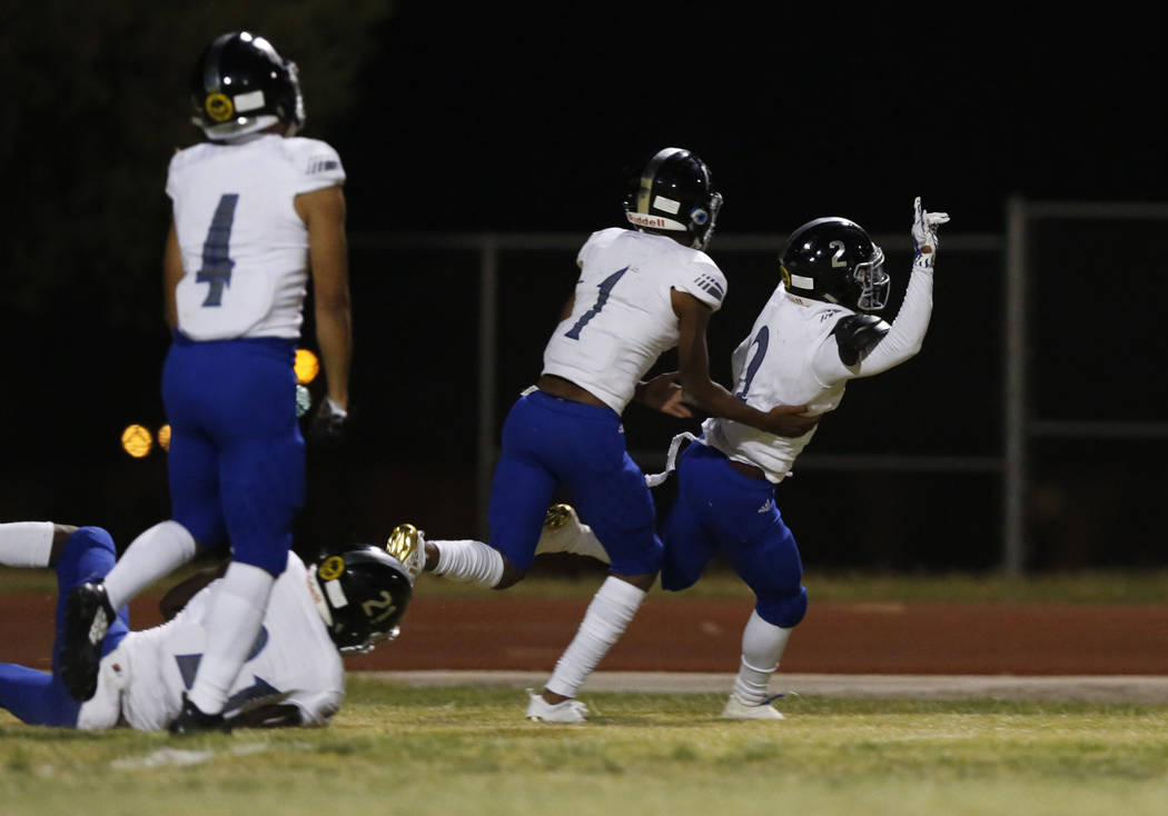 Desert Pines’ Tye Moore, right, celebrates his touchdown with his teammates including ...
