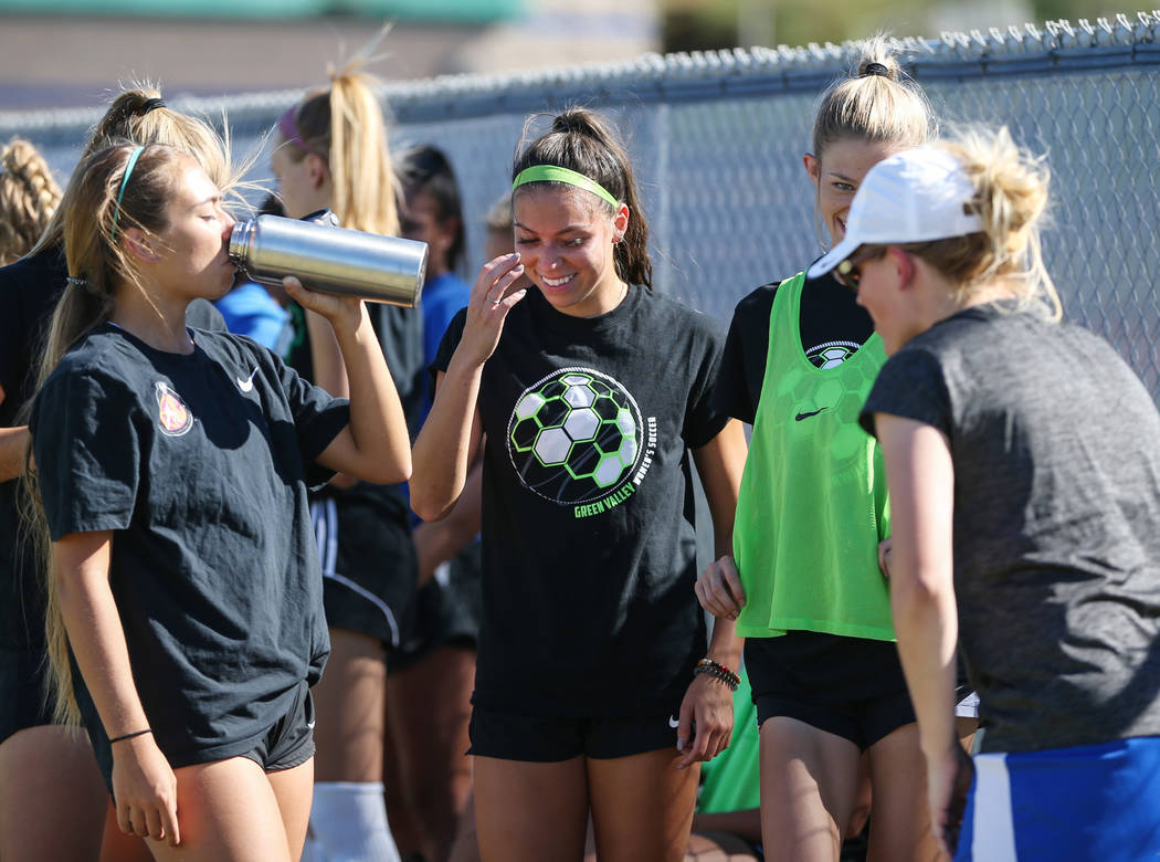 Green Valley’s Taylor O’Neill, 17, laughs with her teammates as they take a wate ...