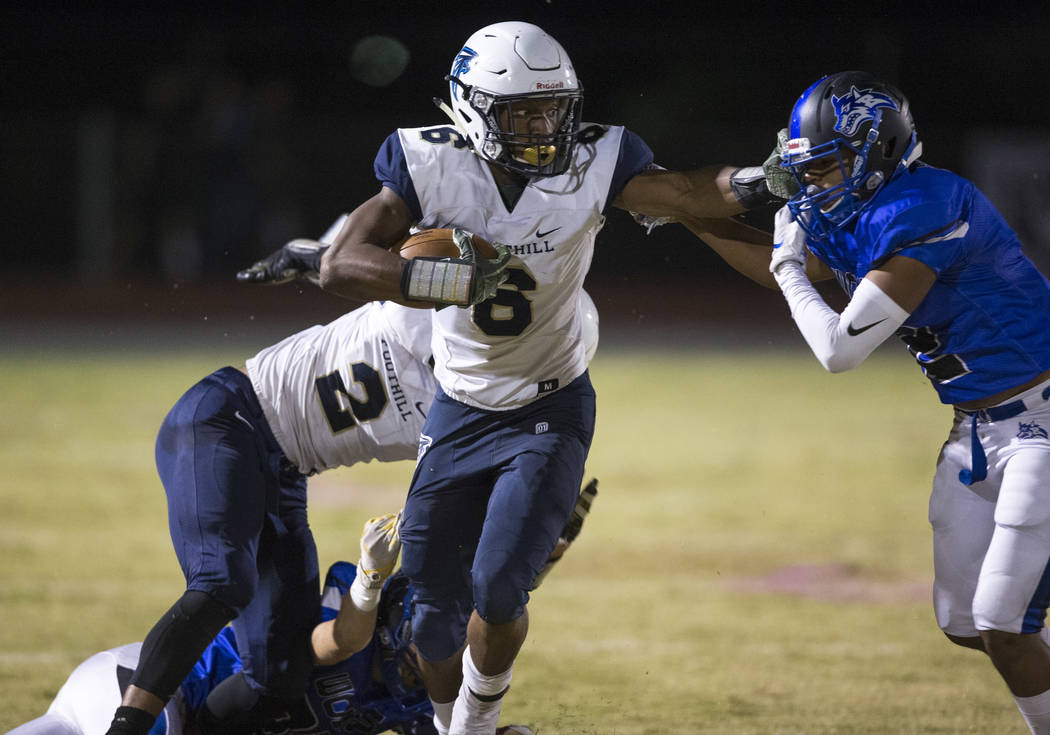 Foothill’s Jordan Wilson (6), center, stiffs arms Basic’s Christopher Render (2) ...