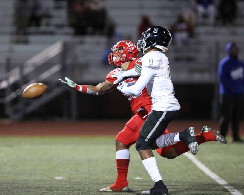 Desert Pines’ Corey Clark (9) blocks Arbor View’s Kyle Graham (25) from catching ...