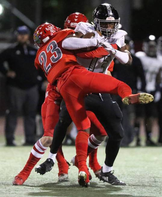 Desert Pines’ Darnell Washington (13) protects the ball while being tackled by Arbor V ...