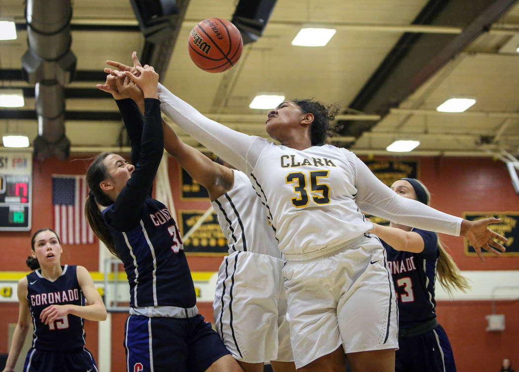 Coronado’s Alexee Johnson (35) and Clark’s Coraly Dupree (35) reach to grab the ...