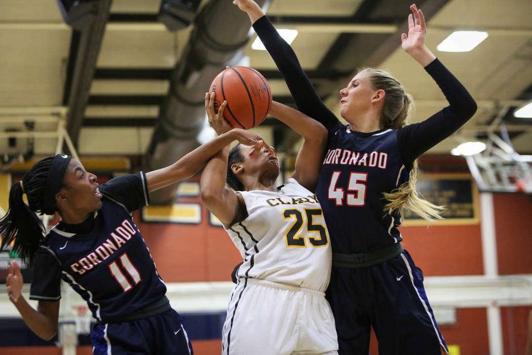 Clark’s Justice Unga (25) fights to keep possession of the ball while being guarded by ...