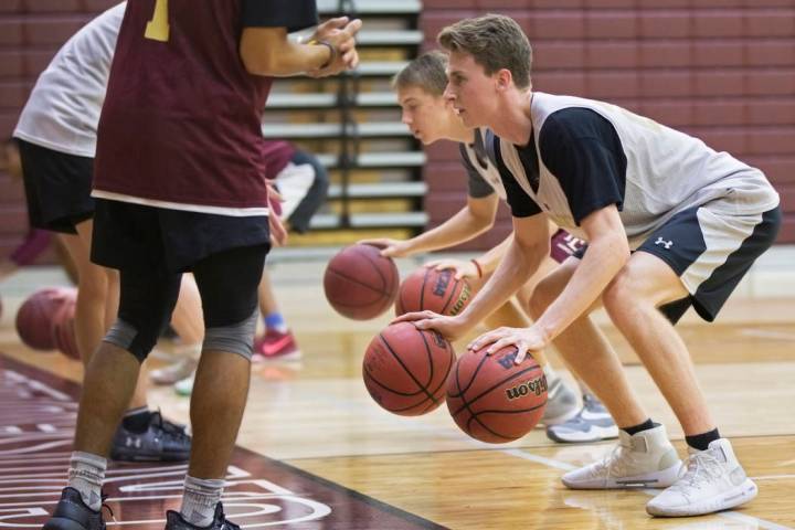 Faith Lutheran senior guard Brevin Walter, right, works through a dribbling drill during pra ...