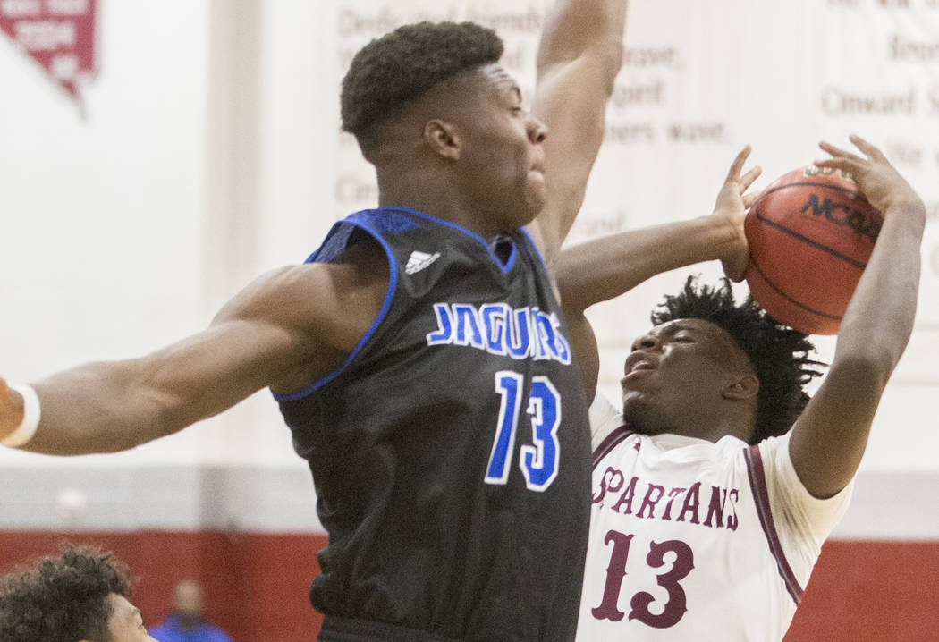 Cimarron-Memorial senior Brian Lang (13) collides with Desert Pines junior Darnell Washingt ...