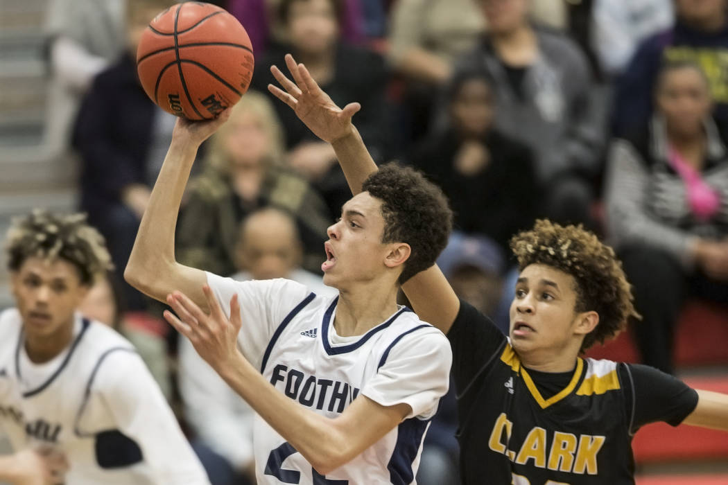 Foothill’s Jace Roquemore (22) slices to the rim past Clark’s Adam Forbes (20) ...