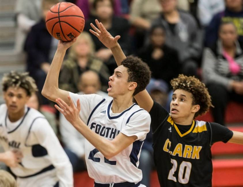 Foothill’s Jace Roquemore (22) slices to the rim past Clark’s Adam Forbes (20) ...